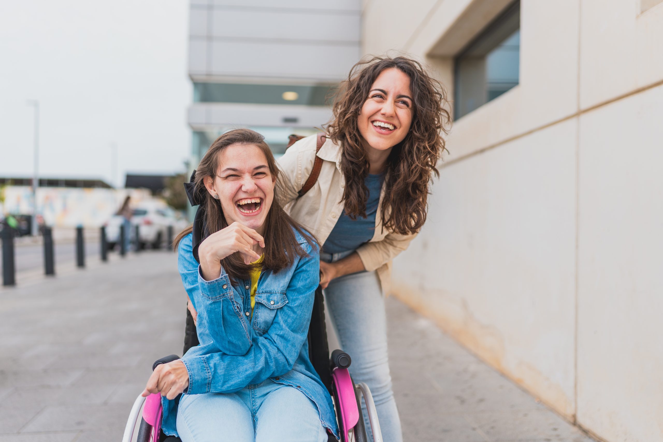 Young,Woman,With,Cerebral,Palsy,Laughs,With,Her,Personal,Assistant