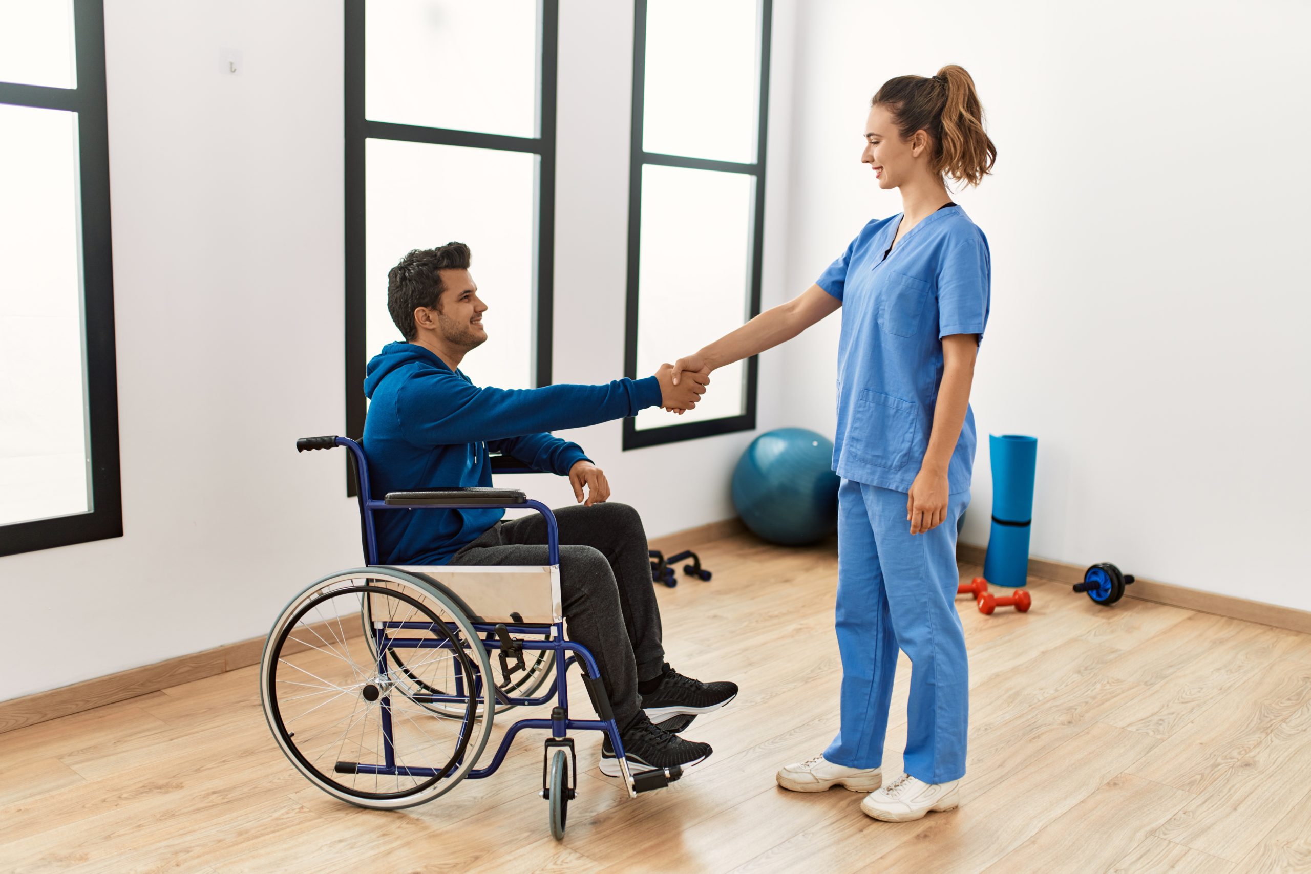 Young,Disabled,Man,And,Physiotherapist,Smiling,Happy,Shaking,Hands,At