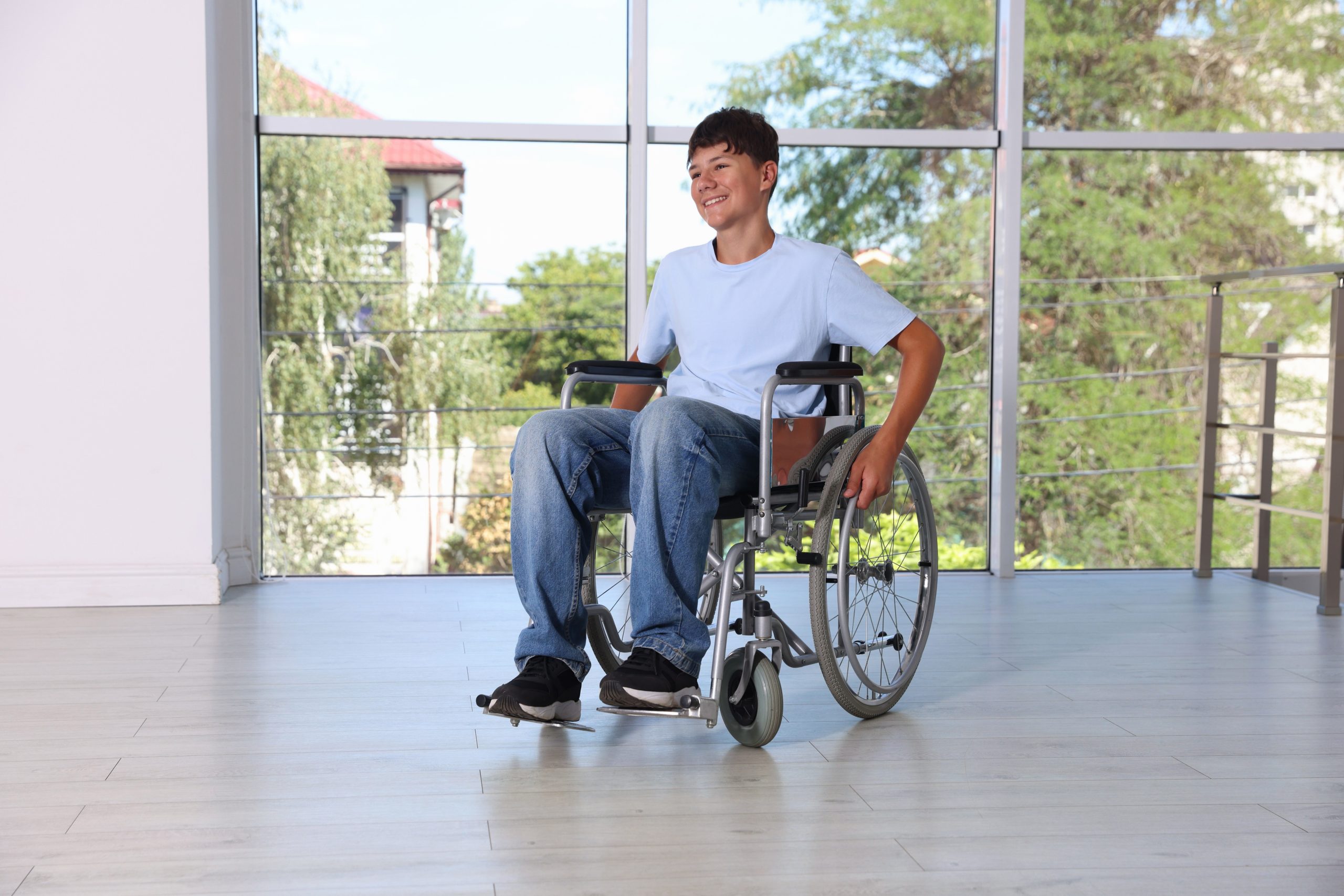 Happy,Teenage,Boy,In,Modern,Wheelchair,Indoors