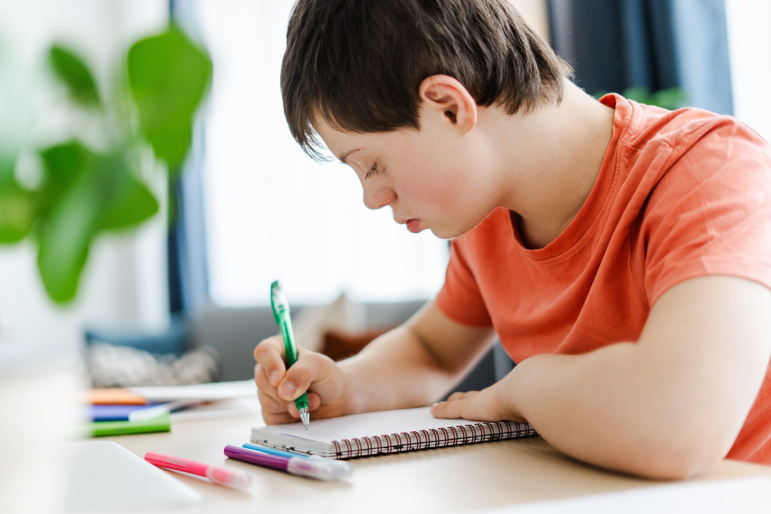 Young,,Smiling,Boy,,Teenager,With,A,Genetic,Condition,Concentrating,While